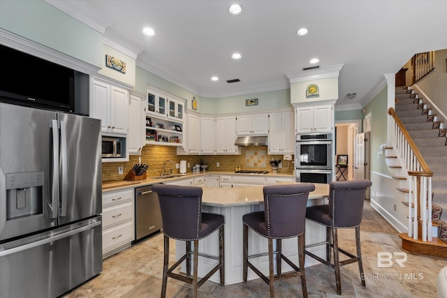 kitchen featuring a center island, white cabinets, sink, tasteful backsplash, and stainless steel appliances