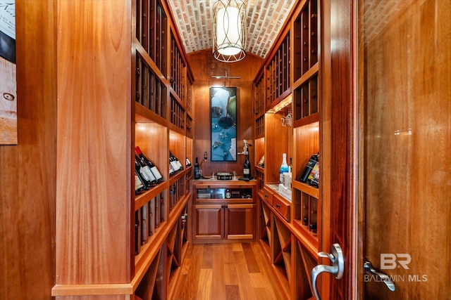 wine cellar with brick ceiling, vaulted ceiling, and light wood-type flooring