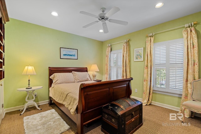 bedroom featuring multiple windows, ceiling fan, and light colored carpet