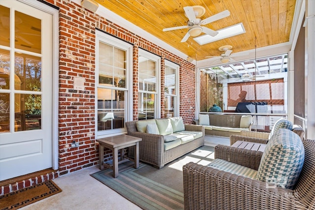 sunroom with a skylight, ceiling fan, plenty of natural light, and wooden ceiling