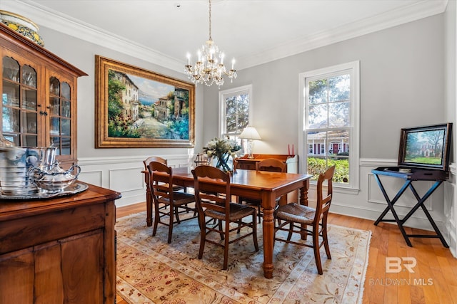 dining room featuring light hardwood / wood-style floors, ornamental molding, and a chandelier