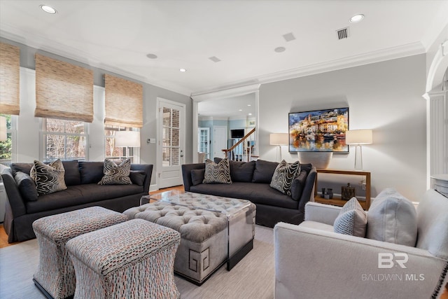 living room with crown molding and light hardwood / wood-style flooring