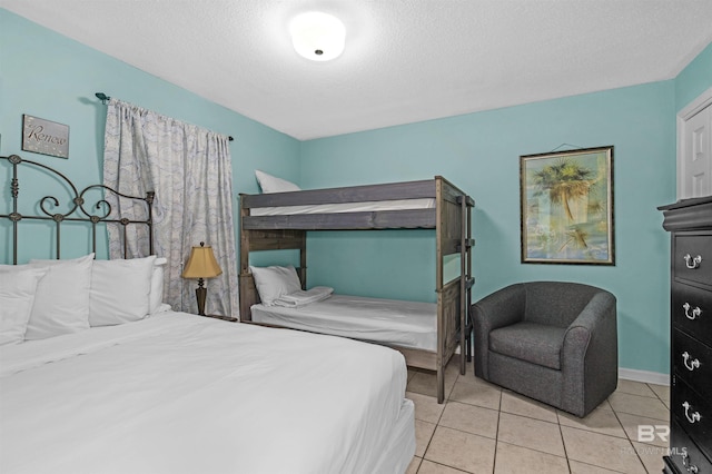 tiled bedroom with a textured ceiling