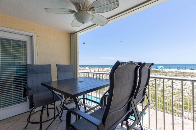 balcony with ceiling fan, a water view, and a beach view