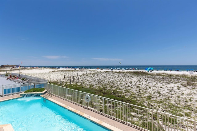 view of swimming pool featuring a beach view and a water view