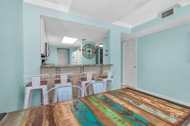 dining room featuring a textured ceiling and crown molding