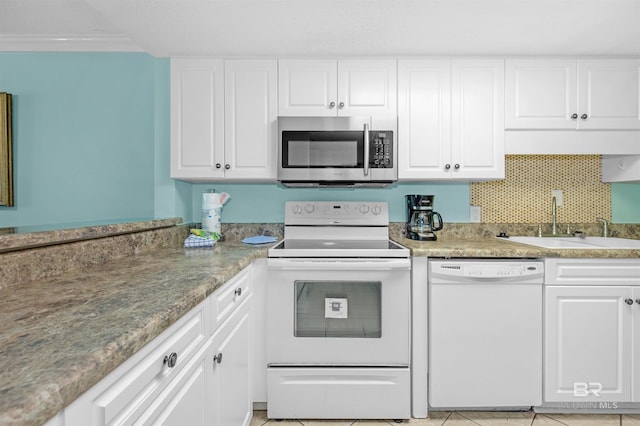 kitchen with white cabinetry, sink, light tile patterned floors, and white appliances