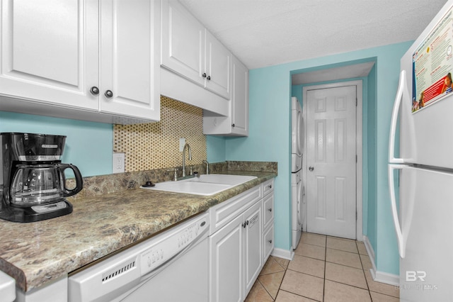 kitchen featuring white cabinetry, sink, tasteful backsplash, white appliances, and light tile patterned floors