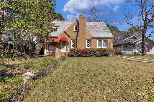1706 Hunter Ave, Mobile, AL 36604 - tudor house featuring a chimney and brick siding