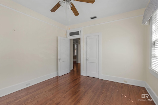 1706 Hunter Ave, Mobile, AL 36604 - unfurnished bedroom with wood finished floors, multiple windows, and a ceiling fan