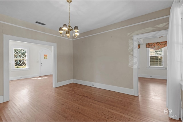 1706 Hunter Ave, Mobile, AL 36604 - spare room featuring wood finished floors, a chandelier, and healthy amount of natural light