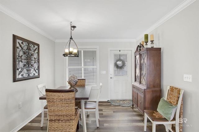 dining room with baseboards, crown molding, wood finished floors, and an inviting chandelier