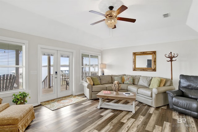 living room with a tray ceiling, french doors, visible vents, ceiling fan, and wood finished floors
