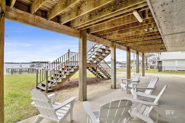 view of patio featuring a water view and stairway