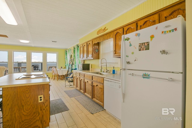 8239 Gulf Beach Ln, Gulf Shores, AL 36542 - kitchen with a kitchen island, white appliances, light countertops, brown cabinets, and a sink