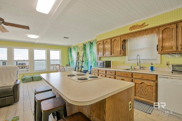 8239 Gulf Beach Ln, Gulf Shores, AL 36542 - kitchen featuring a kitchen island, stovetop, dishwasher, a sink, and a breakfast bar