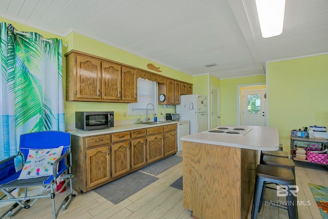 8239 Gulf Beach Ln, Gulf Shores, AL 36542 - kitchen featuring brown cabinets, a sink, light countertops, light wood-style floors, and white appliances
