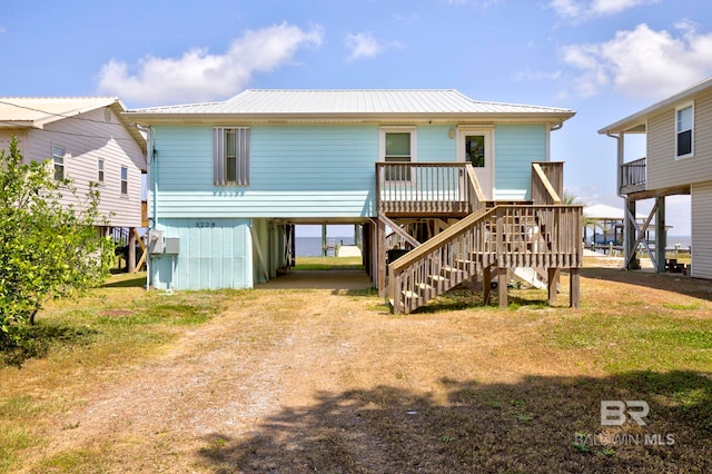 8239 Gulf Beach Ln, Gulf Shores, AL 36542 - rear view of property with stairway, driveway, metal roof, and a carport