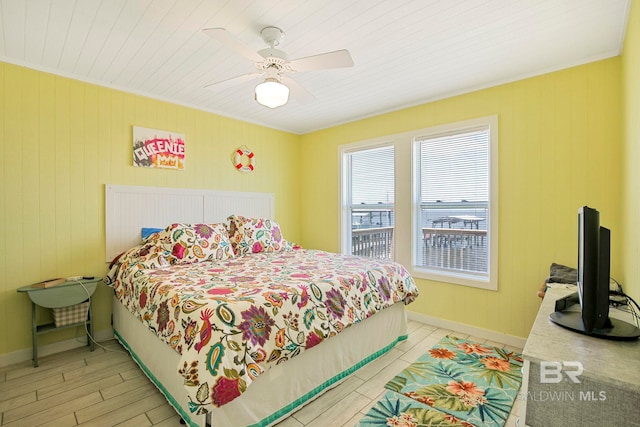 8239 Gulf Beach Ln, Gulf Shores, AL 36542 - bedroom with baseboards, ceiling fan, light wood finished floors, and wood walls
