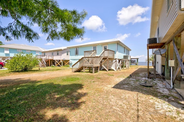 8239 Gulf Beach Ln, Gulf Shores, AL 36542 - rear view of house with a wooden deck, stairs, and a yard