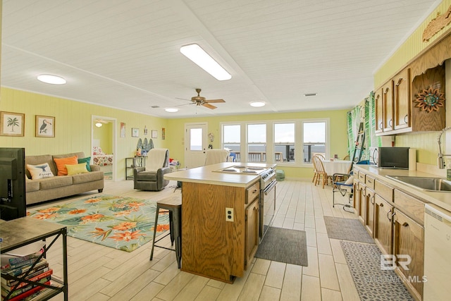 8239 Gulf Beach Ln, Gulf Shores, AL 36542 - kitchen with electric range, a kitchen island, white dishwasher, a breakfast bar area, and stainless steel microwave