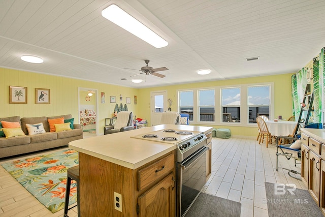 8239 Gulf Beach Ln, Gulf Shores, AL 36542 - kitchen featuring a kitchen breakfast bar, visible vents, a center island, electric stove, and open floor plan