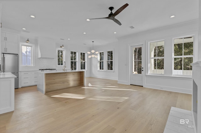 309-C S School St, Fairhope, AL 36532 - unfurnished living room featuring light wood-style flooring, recessed lighting, baseboards, visible vents, and ceiling fan with notable chandelier