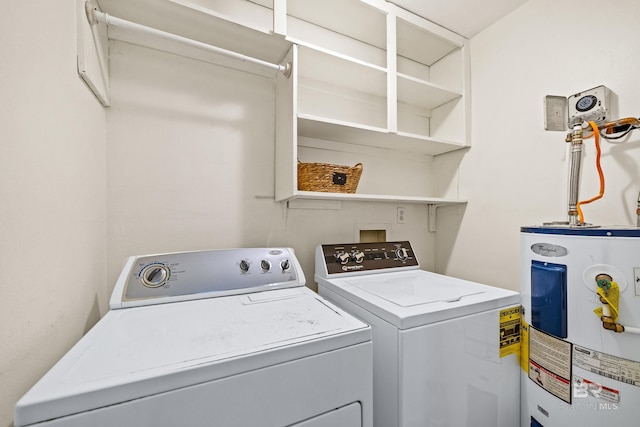 laundry room with separate washer and dryer and water heater