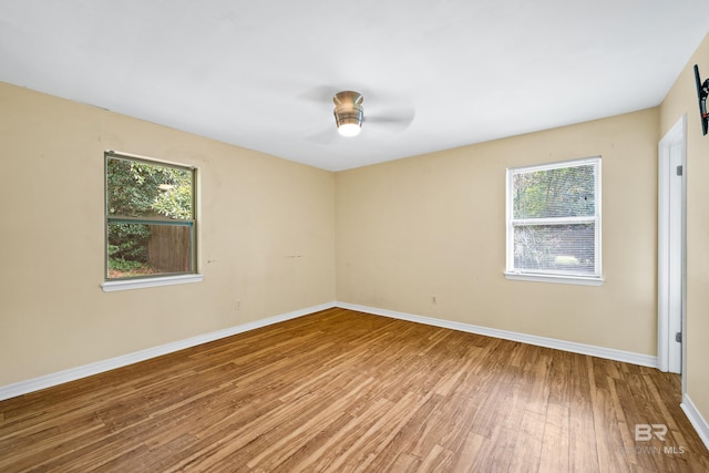 spare room featuring hardwood / wood-style flooring, a wealth of natural light, and ceiling fan