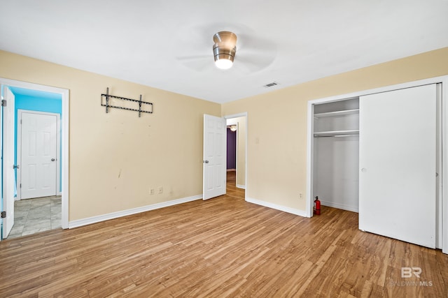 unfurnished bedroom with light hardwood / wood-style floors, a closet, and ceiling fan