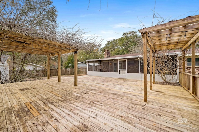 wooden deck featuring a sunroom and a pergola