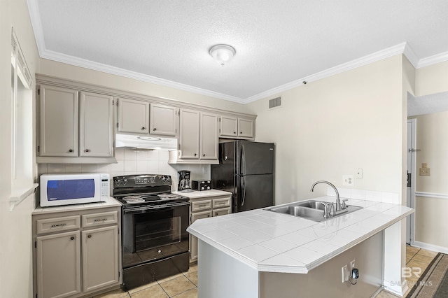 kitchen featuring tile countertops, black appliances, sink, decorative backsplash, and kitchen peninsula