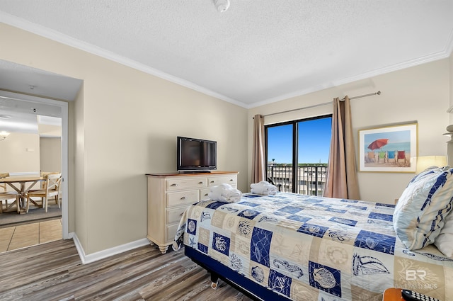 bedroom featuring ornamental molding, access to outside, a textured ceiling, and dark hardwood / wood-style flooring