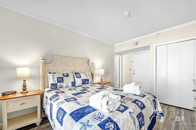 bedroom with a closet, crown molding, and dark hardwood / wood-style floors