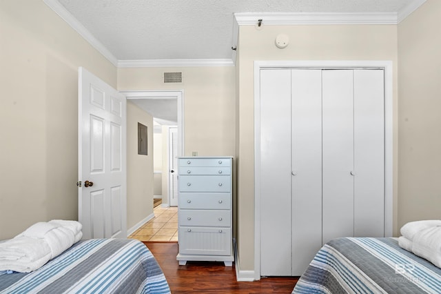 bedroom featuring ornamental molding, dark hardwood / wood-style floors, and a textured ceiling