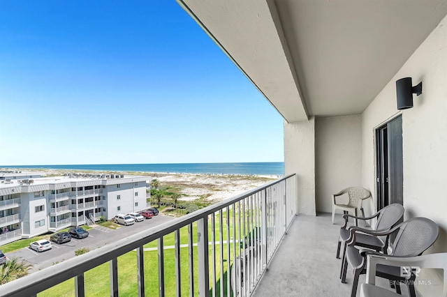 balcony with a water view and a beach view