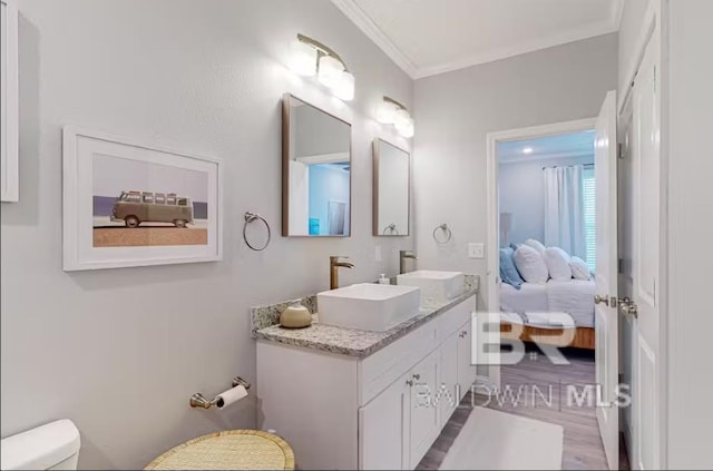 ensuite bathroom with toilet, ensuite bath, crown molding, and a sink