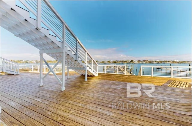 wooden terrace featuring a water view and stairway