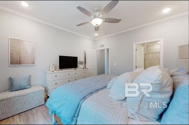 bedroom featuring wood finished floors, visible vents, and crown molding