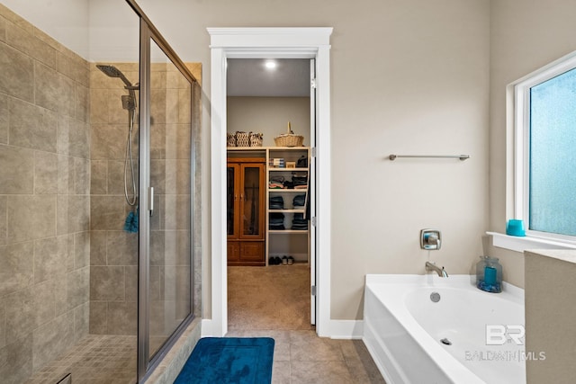 full bathroom with tile patterned floors, a garden tub, a stall shower, and a spacious closet