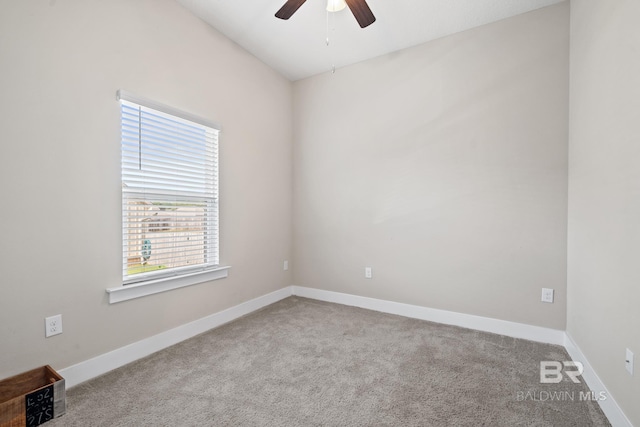 carpeted spare room featuring a ceiling fan and baseboards