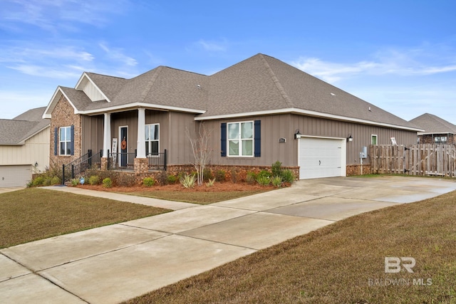 view of front of property with fence, a front yard, roof with shingles, a garage, and driveway