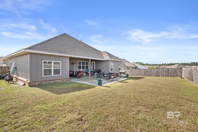 rear view of property with a yard, a patio area, a fenced backyard, and a shingled roof