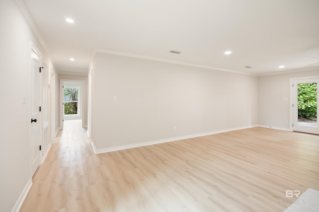 empty room featuring plenty of natural light, light hardwood / wood-style floors, and ornamental molding