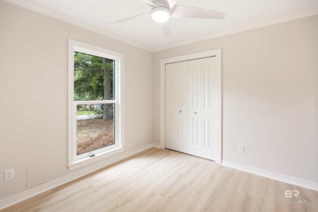 unfurnished bedroom with a closet, light hardwood / wood-style flooring, multiple windows, and ceiling fan