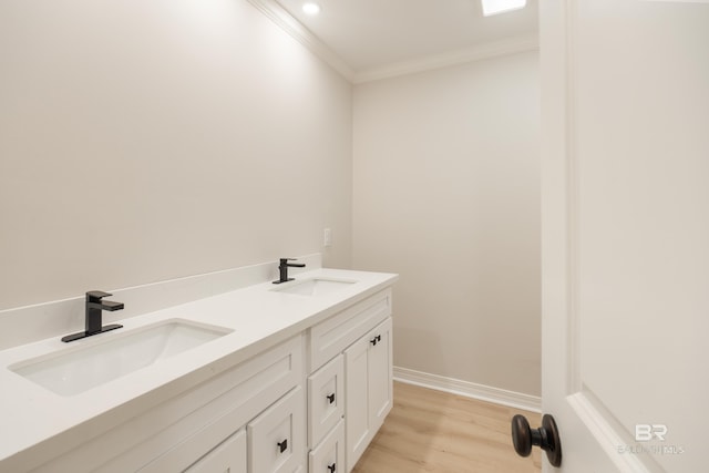 bathroom with vanity, wood-type flooring, and ornamental molding