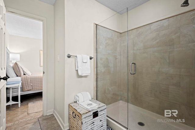 1069 W Beach Blvd Unit 5C, Gulf Shores, AL 36542 - bathroom featuring ensuite bathroom, a stall shower, a textured ceiling, and tile patterned flooring