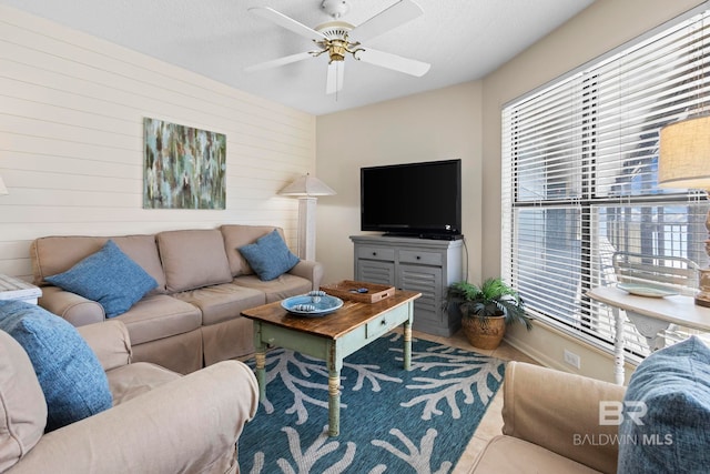 1069 W Beach Blvd Unit 5C, Gulf Shores, AL 36542 - living area with healthy amount of natural light, a ceiling fan, and wood walls