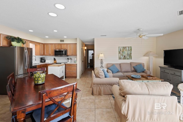 1069 W Beach Blvd Unit 5C, Gulf Shores, AL 36542 - living area featuring light tile patterned floors, a ceiling fan, and a textured ceiling