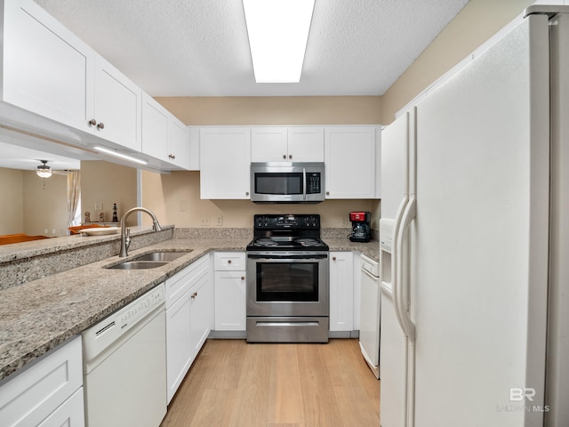 1516 Sandpiper Ln Unit 209, Gulf Shores, AL 36542 - kitchen with white cabinets, light stone counters, sink, and appliances with stainless steel finishes